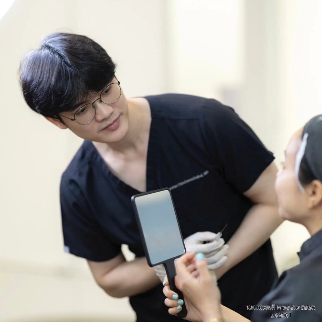 นพ.เทพนที หาญชนะชัยกูล (หมอวิว) ถือกระจกให้ผู้รับบริการดูผลการประเมินผิวหน้า