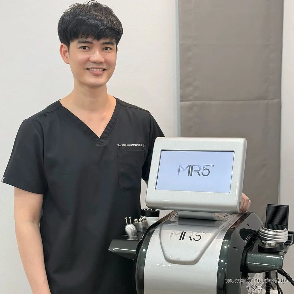 นพ.เทพนที หาญชนะชัยกูล (หมอวิว) ยืนข้างเครื่องทรีทเมนต์ MR5 ที่ VASYL Clinic ขอนแก่น